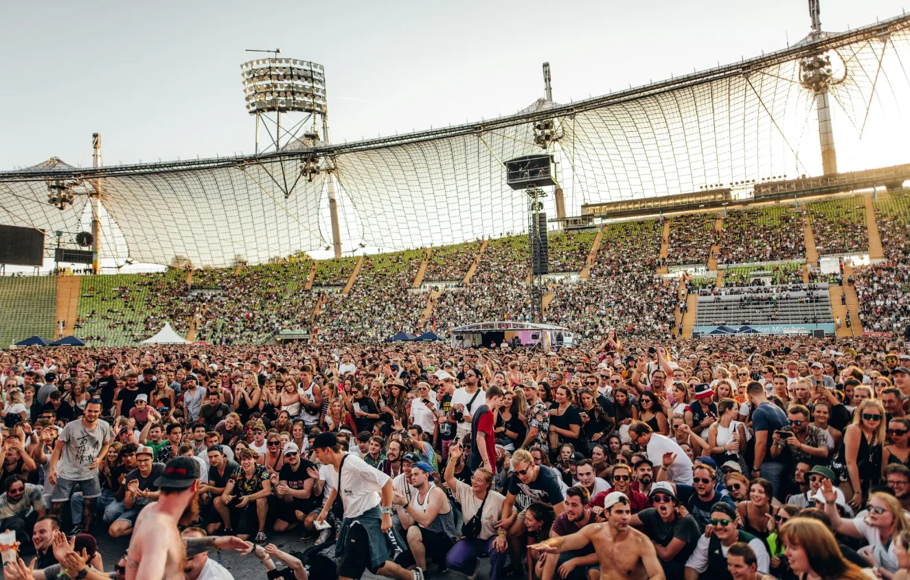 Volles Open-Air-Gelände vor der Bühne an einem Sommerabend